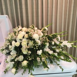 Large white floral spray arranged on a casket