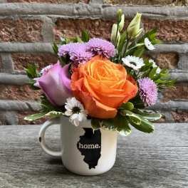 Bouquet of orange and lavender flowers in a white mug