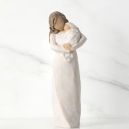 Figurine of a woman holding a baby in a white dress