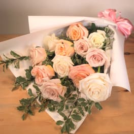 Bouquet of pale pink and cream roses wrapped in white paper