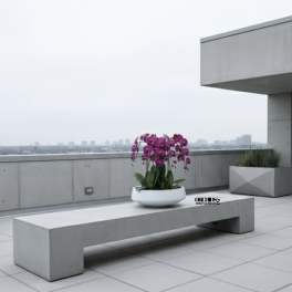 Pink orchids in a white bowl on a concrete bench