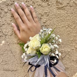 Small wrist corsage with cream roses and white baby's breath