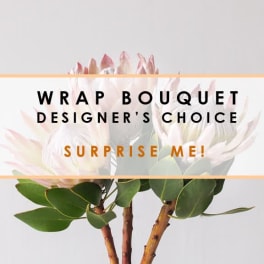 Wrapped bouquet designer's choice with pale pink flowers and green foliage
