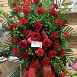 Large red rose and carnation standing spray with ribbon