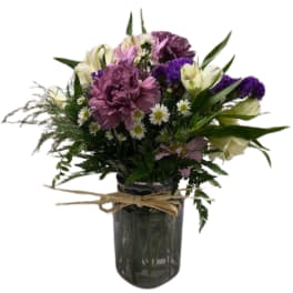 Mixed bouquet of purple and white flowers in a glass vase