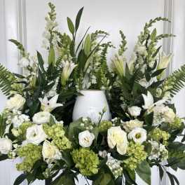 White floral arrangement with lilies, roses, and green hydrangeas in a vase
