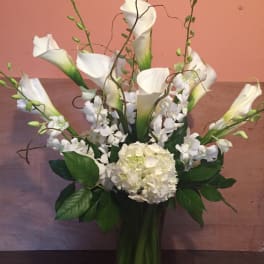 White calla lilies and hydrangea in a tall vase arrangement