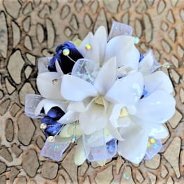 White and dark blue floral corsage with sheer ribbon and sparkly accents
