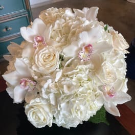 White bouquet with roses, hydrangeas, and orchids
