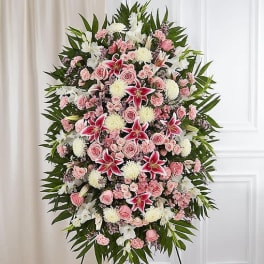 Large standing floral spray with pink and white flowers on a metal easel