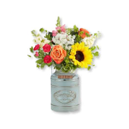 Mixed bouquet with a sunflower, roses, and a blue metal vase