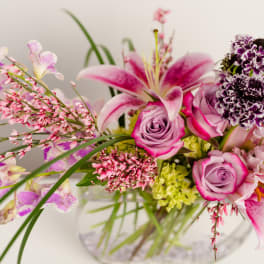 Pink and lavender floral arrangement in a clear glass vase