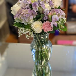 Bouquet of white and lavender flowers in a clear glass vase