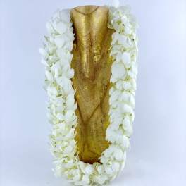 White flower lei draped over a gold decorative object
