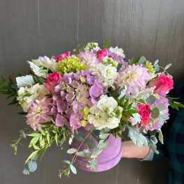 Mixed pink, white, and lavender bouquet in a lavender hat box