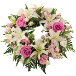 Circular bouquet of pink roses and white lilies with mixed greenery