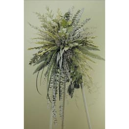 Tall arrangement of mixed greenery with trailing ribbons