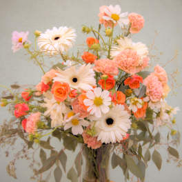 Bouquet of peach and white flowers in a glass vase