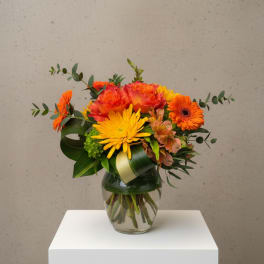 Orange and yellow mixed bouquet in a glass vase