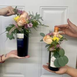 Wine bottles topped with small floral arrangements