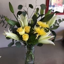 Yellow roses and white lilies in a glass vase