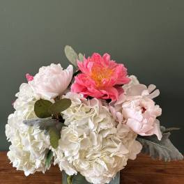 Pink and white peonies with hydrangeas in a glass vase