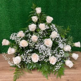 White rose arrangement with baby's breath on a green backdrop