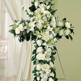White floral cross arrangement on an easel