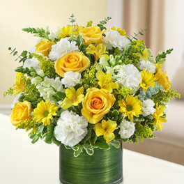 Yellow roses and white carnations in a green cylindrical vase