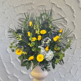 Yellow roses and mixed blooms in a white vase