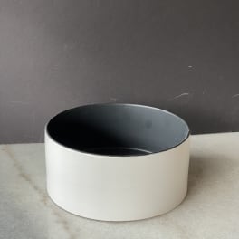 Empty round white planter with a dark interior