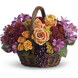 Basket of peach roses and purple flowers