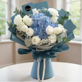 Bouquet of white roses and blue hydrangeas wrapped in blue paper