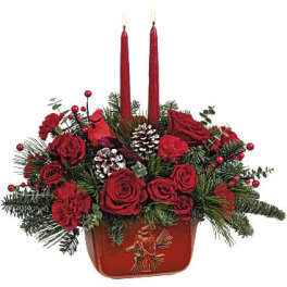Red rose arrangement with two tall red candles in a red container