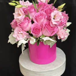 Pink roses and lisianthus arranged in a bright pink vase