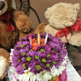 Purple and white daisy bouquet with orange roses and birthday candles