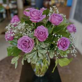 Bouquet of pink roses with baby's breath in a glass vase