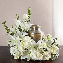 White floral arrangement surrounding a metal urn