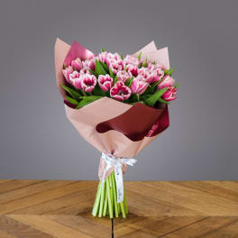 Bouquet of pink tulips wrapped in blush and burgundy paper