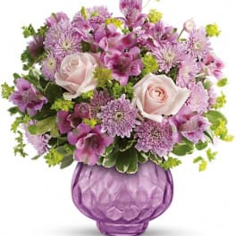 Pink and lavender bouquet in a purple glass vase