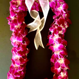 Pink orchid lei with a white ribbon bow