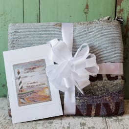 Folded textile gift with a white ribbon and greeting card
