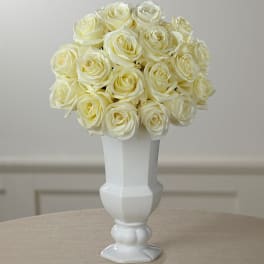 Cream rose bouquet in a white pedestal vase