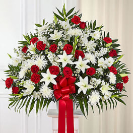 Large red and white floral standing spray with a red ribbon