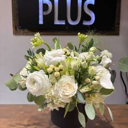 White floral arrangement in a black pedestal vase