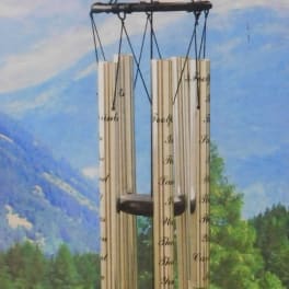 Decorative wind chime with a lighthouse medallion and hanging metal tubes