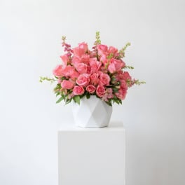 Pink roses arranged in a white geometric vase