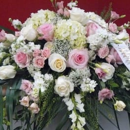 Large pink and white floral spray with a ribbon on a red background