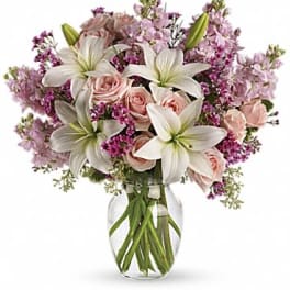 Pink roses and white lilies in a glass vase