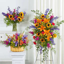 Bright mixed flower arrangements with sunflowers and lilies in a vase and basket.